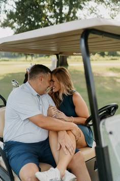 a man and woman sitting in a golf cart