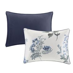 two pillows with blue flowers on them and one has a dark blue pillow cover over it