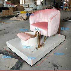 a pink and gold chair sitting on top of a white platform with measurements for the seat