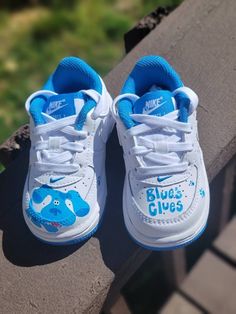 a pair of blue and white shoes sitting on top of a wooden bench