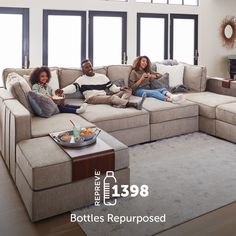 three people sitting on a couch in a living room