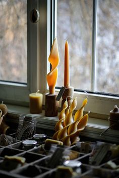 some candles are sitting on a window sill