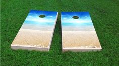 two beach themed cornhole boards laying in the grass