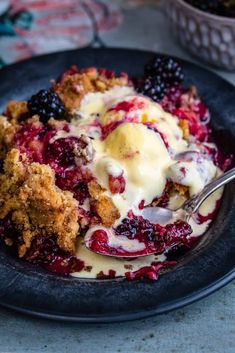 a black plate topped with berries and ice cream