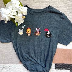 Some of your cute Studio Ghibli characters representing all the four seasons of the year on a shirt! * Totoro represents Spring * Calcifer represents Summer * Jiji represents Autumn * Kaonashi represents Winter Shirts are available in heather gray and black  HOW TO ORDER  → Please pick your t-shirt size → Please pick your t-shirt color → Select the quantity → Click add to cart  ABOUT PPRODUCT  Brand of Shirt: GILDAN Softstyle Solid Colors: 35/65 cotton/polyester Tearaway label All shirts are ver Fun Anime Print Crew Neck T-shirt, Cotton Fandom Shirt With Cartoon Print, Fandom Halloween Short Sleeve Tops, Fan-themed Short Sleeve Tops, Halloween Fandom Short Sleeve Tops, Themed Short Sleeve Tops For Fan Conventions, Themed Short Sleeve Tops For Fan Events, Short Sleeve Cartoon Print Fandom Tops, Fun Cartoon Print Tops For Fan Conventions