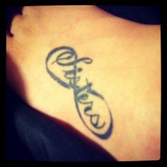 an arabic tattoo on the back of a woman's lower leg, with words written in cursive writing