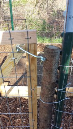 the fence is made out of wood and wire, with a wooden post attached to it