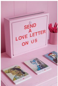 there is a pink box that says send a love letter on us next to four cards