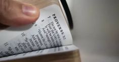 a close up of a person reading a book with their hand on top of it