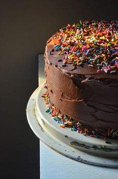 a chocolate frosted cake with sprinkles on top