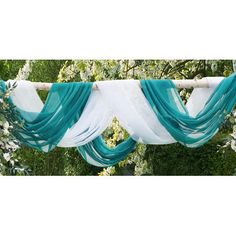 a white and teal drape draped over a tree