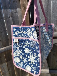 a blue and white bag hanging from a wooden fence