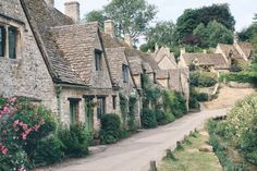 an old village with stone buildings and flowers growing on the side of it's sides