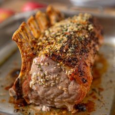 a piece of meat sitting on top of a pan covered in spices and seasoning