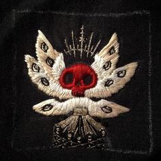 an embroidered skull with feathers on it