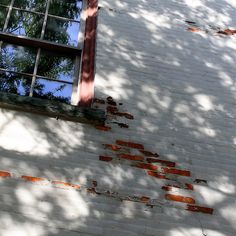 a window on the side of a white brick building