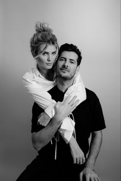 a man and woman are posing for a black and white photo with their arms around each other