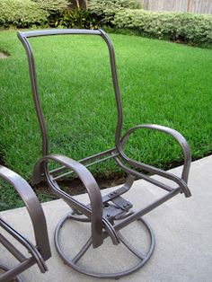 a metal chair sitting on top of a cement floor next to a lush green field