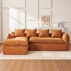 an orange couch sitting on top of a hard wood floor next to a white rug