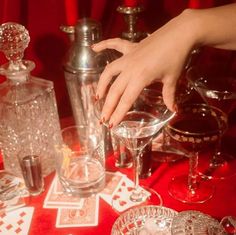 a table topped with lots of glassware and playing cards