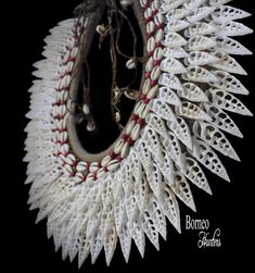 a white and red beaded necklace on a black background