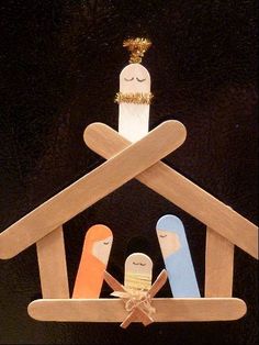 two wooden nativity figurines hanging from the ceiling