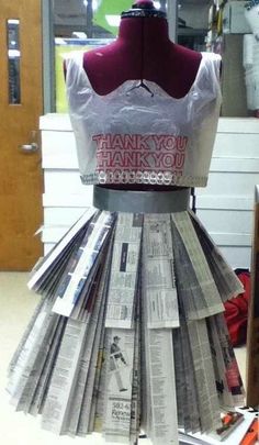 a dress made out of newspapers sitting on top of a table