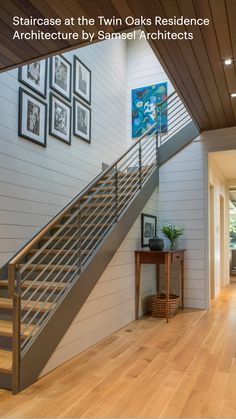 a wooden floor with stairs and pictures on the wall next to it in a house