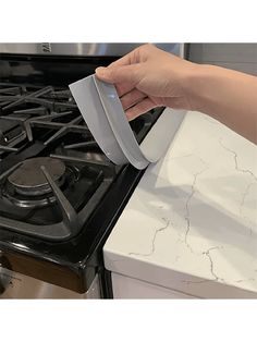 a person is opening the door to an oven with a paper towel on top of it