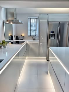 a modern kitchen with stainless steel appliances and white countertops, lighting up the room