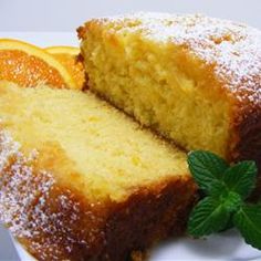 two slices of orange pound cake on a white plate with fresh mint sprig