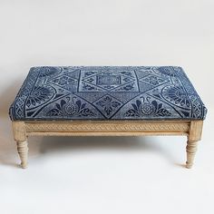 a blue and white ottoman sitting on top of a wooden table