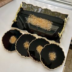 three black and gold serving trays sitting on a table with white counter top in the background