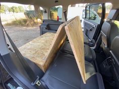 the back seat of a car with a wooden table on it's side door