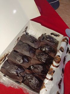 a box filled with chocolate brownies on top of a red table