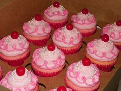 a box filled with pink cupcakes covered in frosting