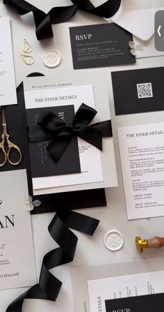 black and white wedding stationery with gold scissors, ribbon, and letterpresss