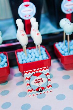 a table topped with red and white bowls filled with blue candies