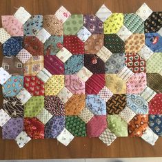 a bunch of different colored ties laid out on top of a wooden table next to each other