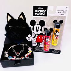 the mickey mouse bracelet is in its box and next to it's contents are other disney merchandise