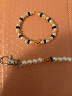 a beaded bracelet with a smiley face on it and a keychain attached