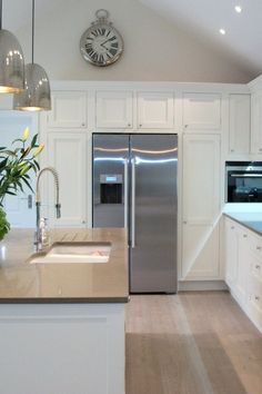 a modern kitchen with stainless steel appliances and white cabinetry is pictured in this image