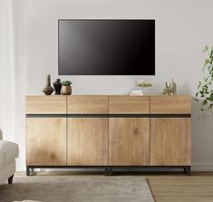 a large flat screen tv mounted to the side of a wooden cabinet