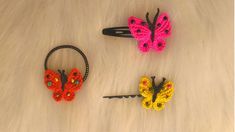 three crocheted butterfly hair clips laying on top of a white fur covered floor