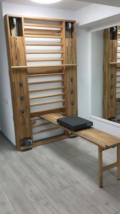 a wooden bench sitting in front of a mirror