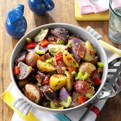 a bowl filled with vegetables sitting on top of a wooden table next to a fork