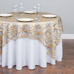 a table topped with plates and glasses on top of a wooden floor