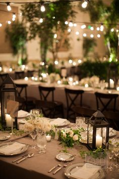 the table is set with candles, plates and silverware for an elegant wedding reception