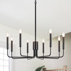 a black chandelier with candles hanging from it