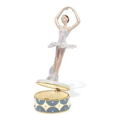 a figurine in the shape of a ballerina on top of a box